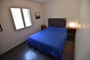 - une chambre avec un lit bleu et une fenêtre dans l'établissement villa des coteaux, à Ners