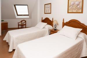 Łóżko lub łóżka w pokoju w obiekcie Apartamentos A Laxe