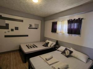 pokój z 2 łóżkami w pokoju w obiekcie AA TRAVELLERS PAD w mieście Laoag