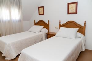 Łóżko lub łóżka w pokoju w obiekcie Apartamentos A Laxe