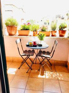 stół i krzesła na balkonie z doniczkami w obiekcie Green Guesthouse w Rzymie +37 zdjęć