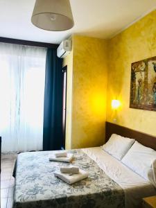 sypialnia z łóżkiem i dwoma ręcznikami na nim w obiekcie Green Guesthouse w Rzymie