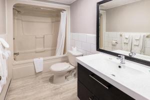 y baño con aseo, lavabo y ducha. en First Canada Hotel Cornwall Hwy 401 ON en Cornwall