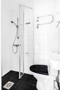 e bagno con doccia, servizi igienici e lavandino. di WeHost 1BR Scandinavian Style Top Floor Apartment a Helsinki