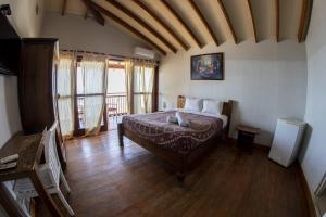 a bedroom with a bed in a room with wooden floors at Don Giovanni Mancora in Máncora