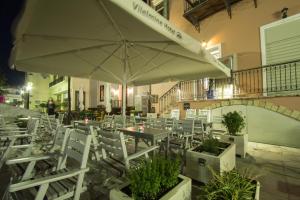 un restaurant avec des tables, des chaises et un parasol dans l'établissement Vilelmine, à La Canée