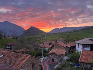 una puesta de sol sobre un pueblo con montañas en el fondo en La Posada de la Valuisilla - Bed&Breakfast, en Cicera