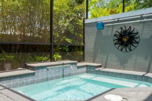 a swimming pool with a clock on the wall at Fun Vacation Home Close to Disney and Outlets at Le Reve Resort 4449 in Kissimmee