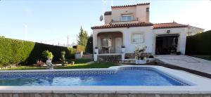 uma villa com piscina em frente a uma casa em Villa Rosa de los Vientos em Les tres Cales
