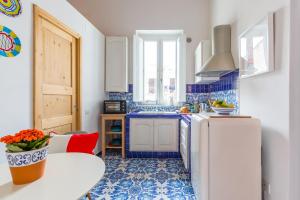 kuchnia z niebiesko-białymi kafelkami i lodówką w obiekcie Starhost - La Casa al Duomo w mieście Vietri sul Mare