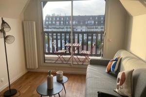 a living room with a couch and a large window at Nice 41 M With Balcony Near The Beach in Deauville