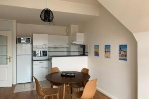 a kitchen with a table and chairs in a room at Nice 41 M With Balcony Near The Beach in Deauville