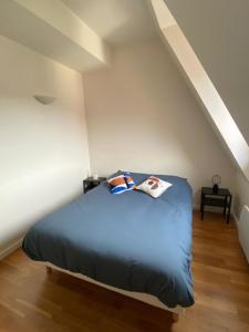 a bedroom with a blue bed in a attic at Nice 41 M With Balcony Near The Beach in Deauville