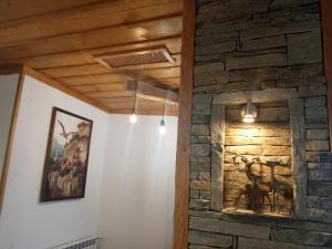 Habitación con una pared de piedra con una pintura y luces. en ArdoHill Hotel and Restaurant, en Sarnitsa