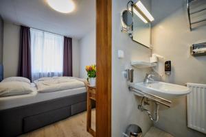 a bedroom with a bed with a sink and a mirror at Hotel Giamas in Straubing