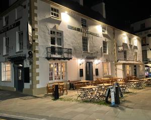 a building with tables and chairs in front of it at Punch House Monmouth in Monmouth