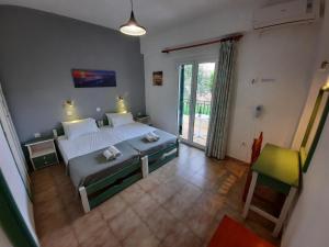una camera con un grande letto e una grande finestra di Oliveland Apartments a Kávos