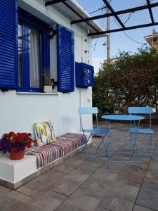 Casa Ble - Izla Homes في سكالا كيفالونياس: مقعد وكرسيين وطاولة على الفناء