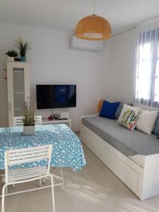 a bedroom with a bed and a table and a tv at Casa Ble - Izla Homes in Skala
