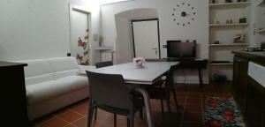 uma sala de estar com uma mesa e um sofá branco em Il Sasso appartamento em Orta San Giulio