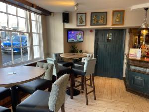 un restaurante con mesas y sillas y un bar en Punch House Monmouth en Monmouth