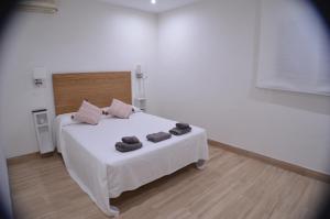 Un dormitorio con una cama blanca con dos toallas encima. en EL ENCANTO Chiclana, en Chiclana de la Frontera 44 fotos más