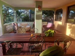 a wooden table and chairs on a screened in porch at La Hacienda Hostel-Rancho in Las Galeras