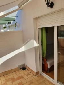 サアラ・デ・ロス・アトゥネスにあるApartamentos Vacacionales Atlanterraのパティオにつながるガラスのスライドドアが付いた客室です。