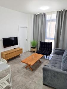 uma sala de estar com um sofá e uma mesa de centro em Sima Suite em Ashdod