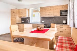 een keuken met houten kasten en een houten tafel bij Ferienhaus Weitblick in Flachau