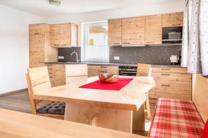 kuchnia z drewnianymi szafkami i drewnianym stołem w obiekcie Ferienhaus Weitblick w mieście Flachau +31 zdjęć