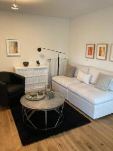 a living room with a white couch and a table at Ferienwohnung Hafenglück, Villa Vilmblick in Lauterbach