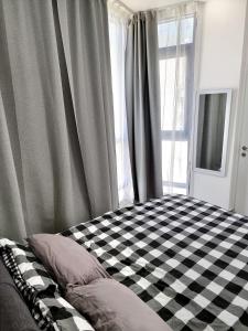 a bedroom with a checkered bed in front of a window at Sima Suite in Ashdod
