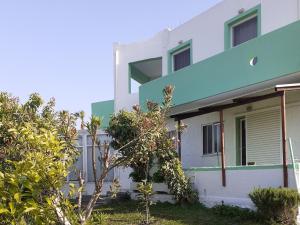 un edificio bianco e blu con alberi di fronte di Zikas apartments a Marmári