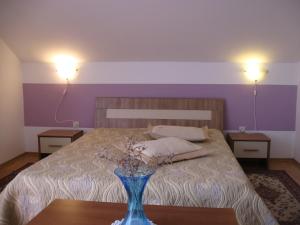 a bedroom with a bed with a blue vase on a table at Madam Svetlana in Tivat