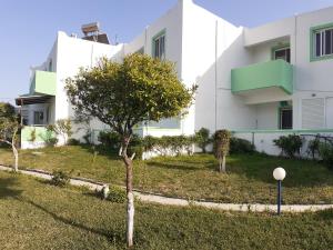 a building with a tree in front of it at Zikas apartments in Marmari