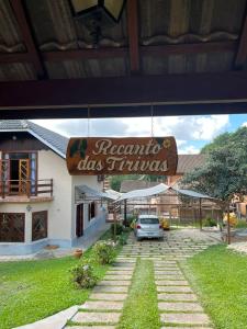 a sign for a restaurant with a car parked outside at Recanto das Tirivas in Monte Verde