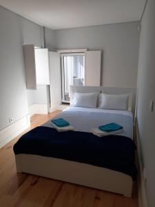 una camera da letto con un letto grande con due asciugamani sopra di São Bartolomeu Apartment 2 a Coimbra Altre 7 foto