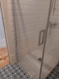 a shower with a glass door in a bathroom at São Bartolomeu Apartment 3 in Coimbra