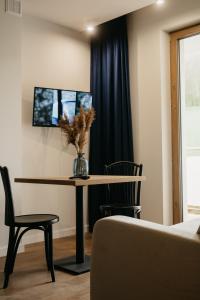 a dining room table with a vase of flowers on it at Rajskie Uroczysko Apartamenty Jacuzzi Sauna in Rajskie Sakowczyk