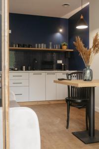 cocina con armarios blancos y mesa de madera en Rajskie Uroczysko Apartamenty Jacuzzi Sauna, en Rajskie Sakowczyk