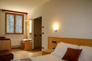 una camera con letto e luce sul muro di hotel Parco Pineta a Cavareno