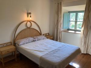 a bedroom with a bed with a blue blanket and a window at La Posada de la Valuisilla - Bed&Breakfast in Cicera