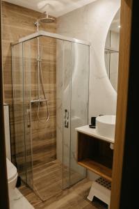 y baño con ducha y lavamanos. en Rajskie Uroczysko Apartamenty Jacuzzi Sauna, en Rajskie Sakowczyk