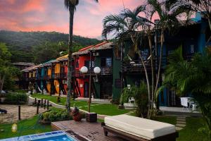 uma vista para um resort com uma piscina e palmeiras em Saint Germain - Lagoa da Conceição em Florianópolis