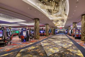 a casino with many slot machines and a chandelier at Hyatt Regency JFK Airport at Resorts World New York in Queens
