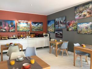 une cuisine et une salle à manger avec des tables et des chaises dans l'établissement Le Clos du Peintre, à Sarlat-la-Canéda