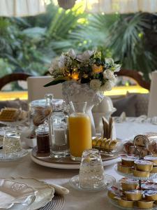 stół z wazonem kwiatów i sokiem pomarańczowym w obiekcie B&B Le Lanterne w mieście Casal Palocco
