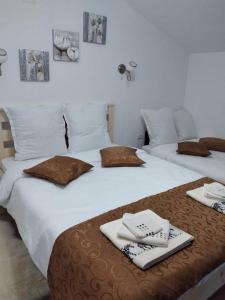 duas camas com toalhas e guardanapos por cima em Casa Savu Secaria em Secăria