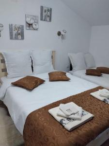 two beds with towels and napkins on top of them at Casa Savu Secaria in Secăria